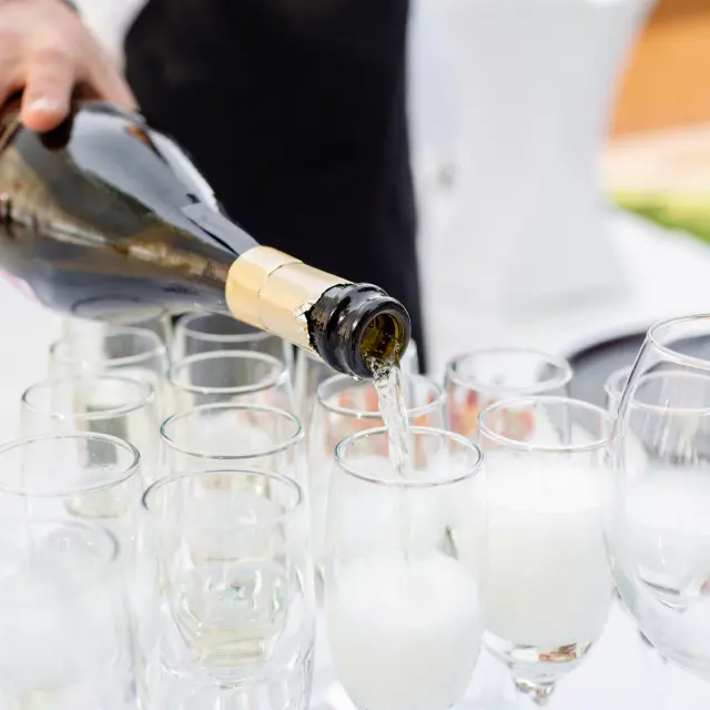 Person pours champagne into a glass