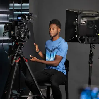 Marques sitting surrounded by lightting equipment