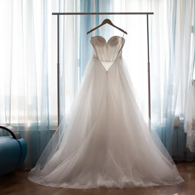 Wedding dress hanging in front of window